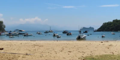 Uitzicht vanaf een strand op Ilha Grande met boten en een cruiseschip